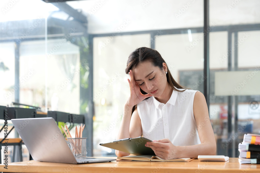 Young Business Asian women are stressed while working on laptop, Tired asian businesswoman with headache at office, feeling sick at work copy space in workplace an home office. Young Business Asian women are stressed while working on laptop, Tired asian businesswoman with headache at office, feeling sick at work copy space in workplace an home office.