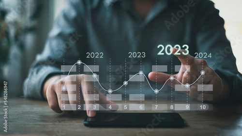 Businessman concept, analyzing workability and examining information for investment with new digital virtual screen graphics, 2023.