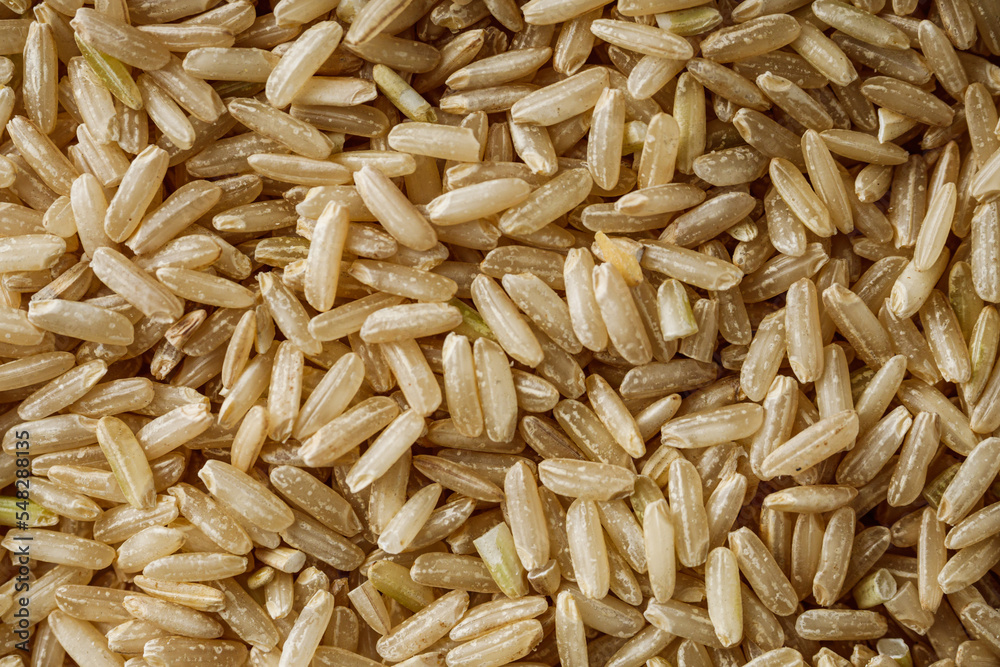 raw unpolished rice on a white acrylic background raw unpolished rice on a white acrylic background