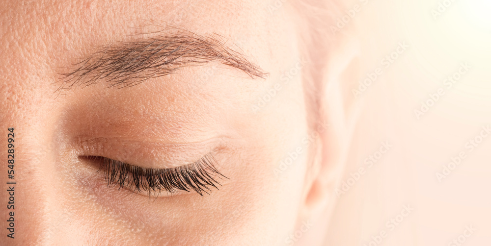 Obraz premium Beautiful female eyebrow and eyelashes. Part of the face close-up with space for text. The concept of cosmetics and make-up. copy space