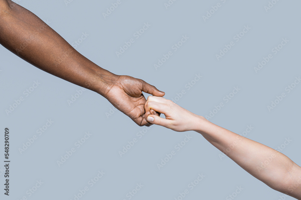 Woman and african woman hand. Helping hand, Rescue, multiathnic people. Helping hands, Rescue gesture. Black and white human hands. African and caucasian hands. Giving a helping hand to another Woman and african woman hand. Helping hand, Rescue, multiathnic people. Helping hands, Rescue gesture. Black and white human hands. African and caucasian hands. Giving a helping hand to another