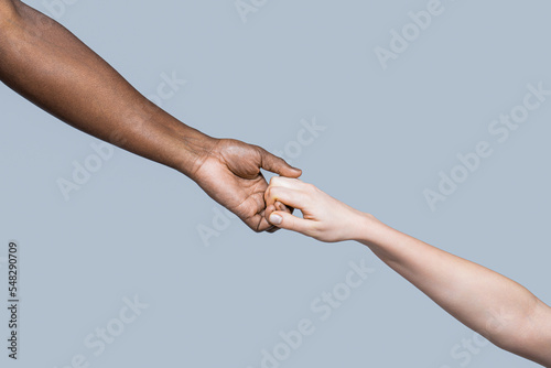 Woman and african woman hand. Helping hand, Rescue, multiathnic people. Helping hands, Rescue gesture. Black and white human hands. African and caucasian hands. Giving a helping hand to another