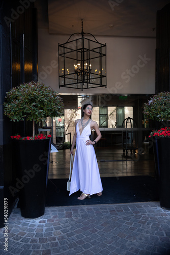 woman in white dress in front of a doorway