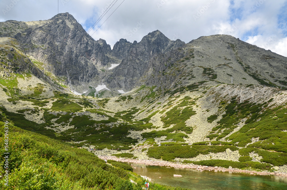 A landscape with one of the most famous mountain lakes in the Slovakian Tatra Mountains, Skalnate Pleso (Rocky Tarn) and Lomnicky peak on background