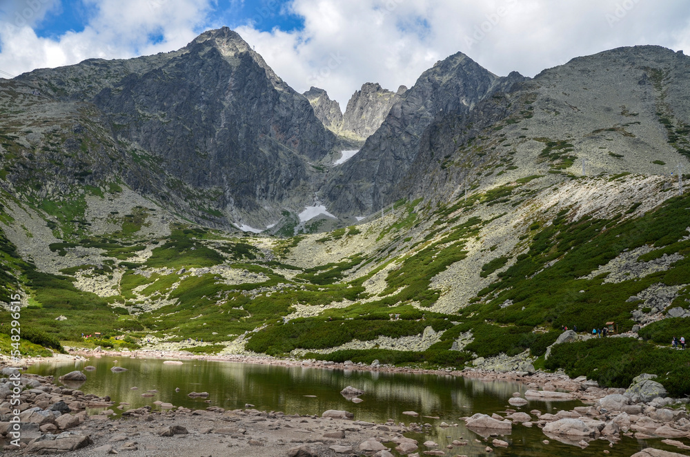A landscape with one of the most famous mountain lakes in the Slovakian Tatra Mountains, Skalnate Pleso (Rocky Tarn) and Lomnicky peak on background