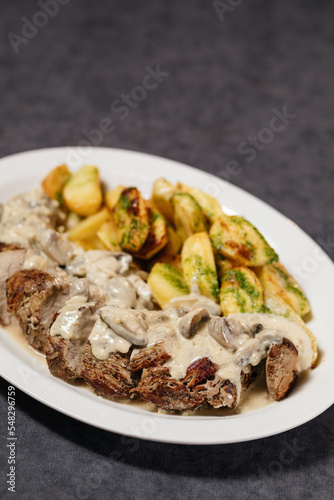 Grilled veal with potatoes and mushroom sauce. Restaurant concept.