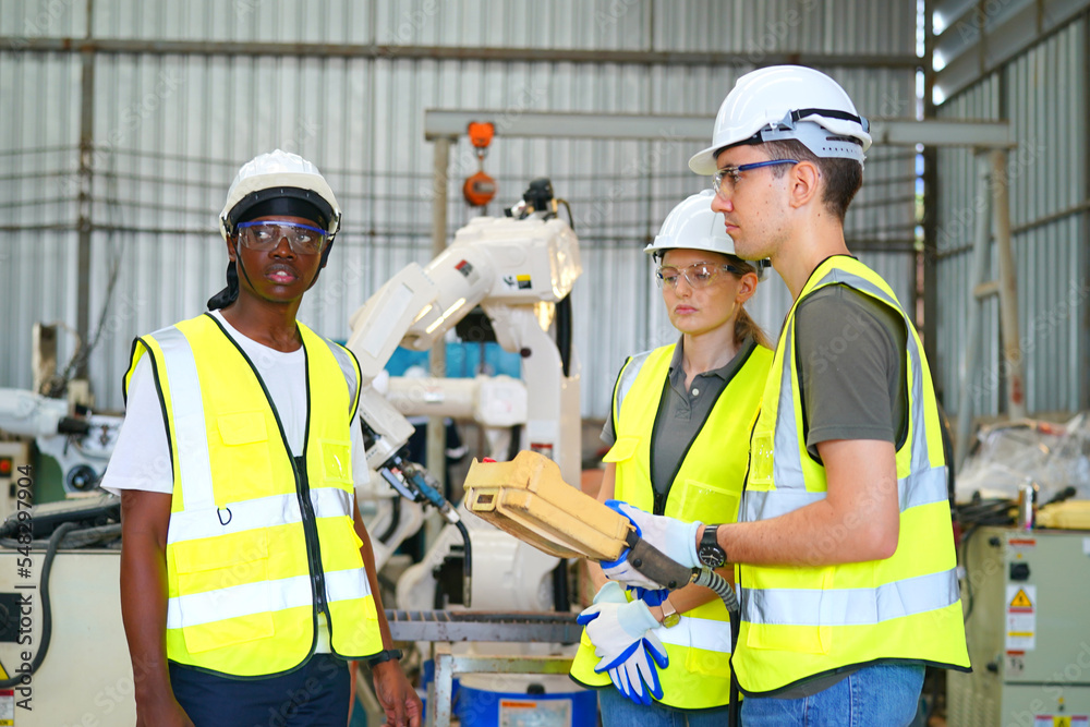 Robotics engineer working on maintenance of modern robotic arm in factory warehouse