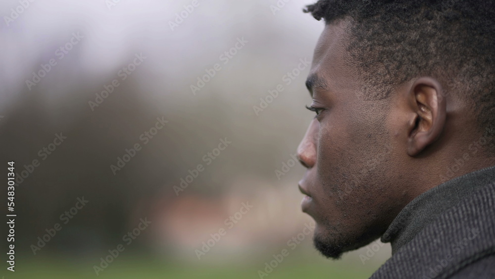 Thoughtful African black man standing outside at park thinking Thoughtful African black man standing outside at park thinking
