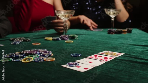 Extreme close-up of poker cards, player checking his hand before making bet. Casino customer playing at table, winning combination strategy, gambling fortune. Lucky tournament winner looking at pair photo