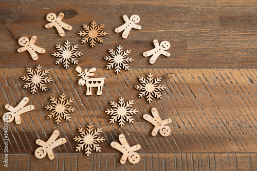 A pattern of Christmas wooden decorations lies on a beautiful wooden table