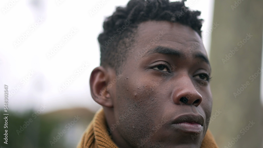 Serious black African man standing at park wearing winter clothing thinking about life2 Serious black African man standing at park wearing winter clothing thinking about life2