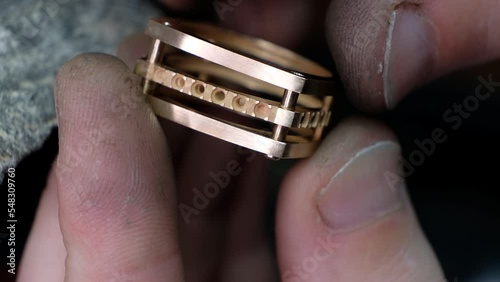 Craft jewelery making. Ring repairing. Putting the diamond on the ring. Macro shot. Craftsman making diamond ring photo