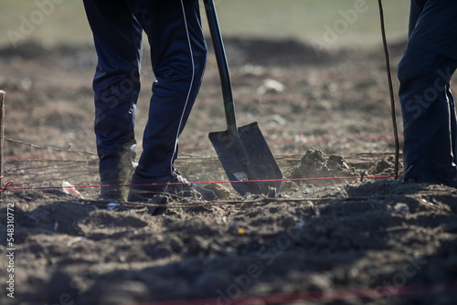 Foto Details with a person shovelling dry, arid and dusty soil during a planting activity