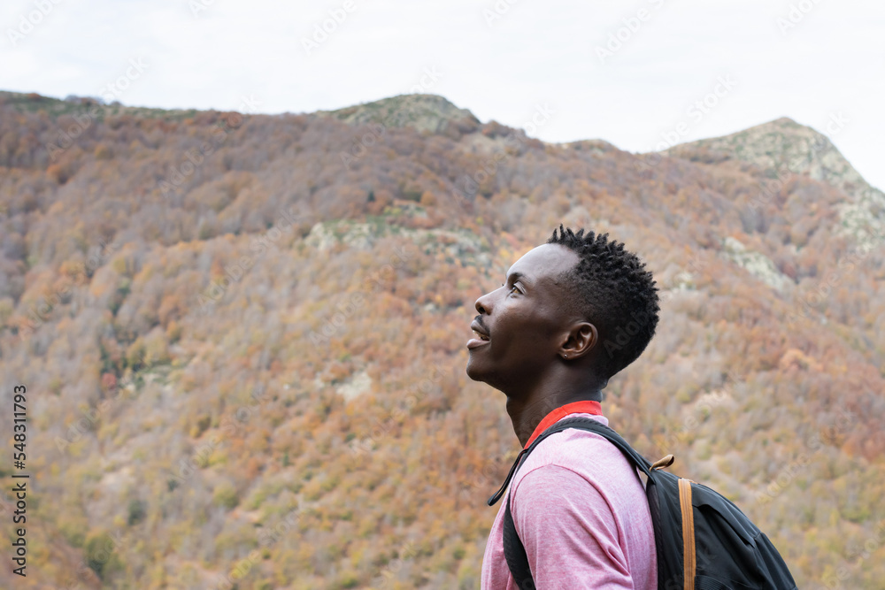 Fototapeta premium Profile of a black-skinned man breathing fresh air at the top of the peak in the Montseny natural park in Barcelona (Spain).