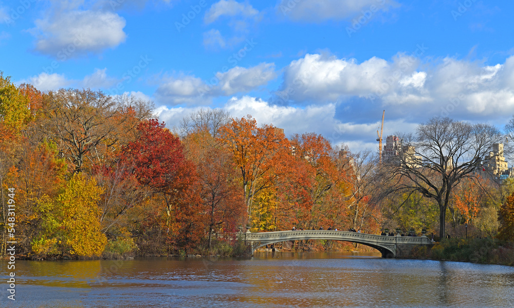 Bow Bridge, cast iron bridge in Central Park, New York City, crossing Lake and used as pedestrian walkway. Golden autumn