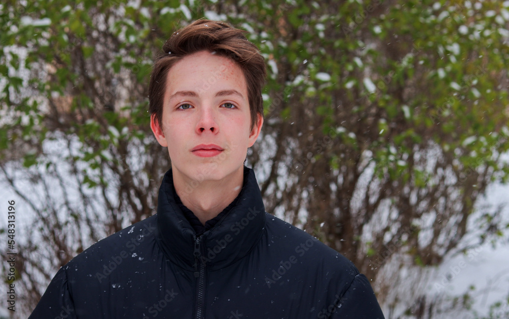 Portrait of a teenage boy close-up on a background of snow.