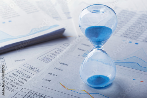 Best time for investment. Hourglass, financial charts and calculator.