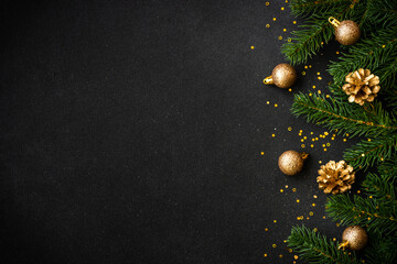 Christmas flat lay background with golden holiday decorations on black. Top view with copy space.