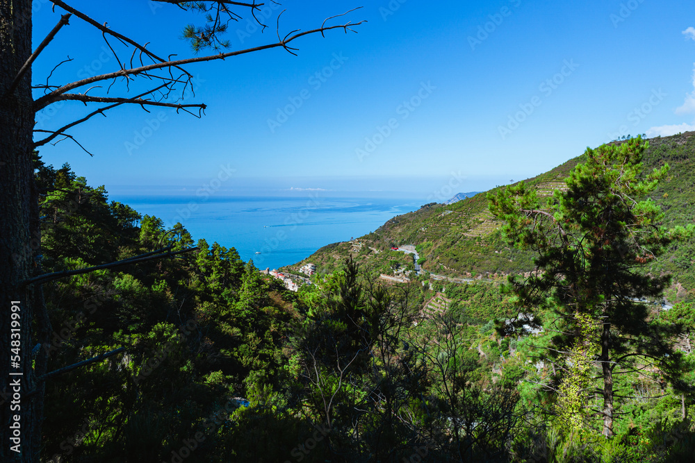 The sea and the landscape of the Cinque Terre, one of the most famous and visited areas in all of Italy, during a sunny day in early autumn, near the town of Riomaggiore, Italy - October 2022.