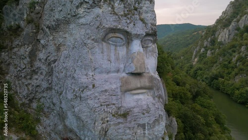 Aerial video of the statue of Decebal, located on the gorges of Danube river in Romania. Video was shoot from a drone with camera lowered with the statue in the view. photo