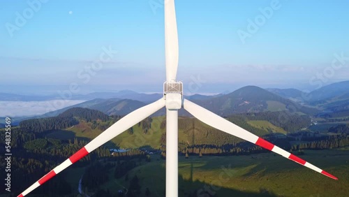 Closeup view of a rotating wind power plant in the mountains	 photo