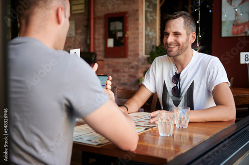 Same sex male couple dining out together.