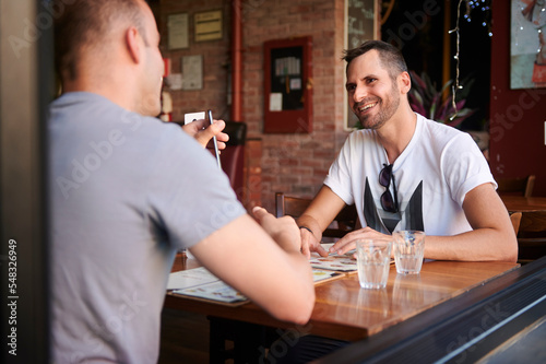 Same sex male couple dining out together.