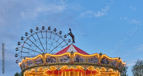 The dome of a children's carousel in a retro style. Evening amusement park. © IrinaK