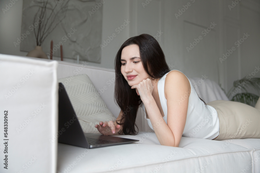 work from vacation home, remote workers. Working from Anywhere. woman freelancer connecting to the Internet from home. The adorable young woman using a laptop, in a stylish living room. work from vacation home, remote workers. Working from Anywhere. woman freelancer connecting to the Internet from home. The adorable young woman using a laptop, in a stylish living room.