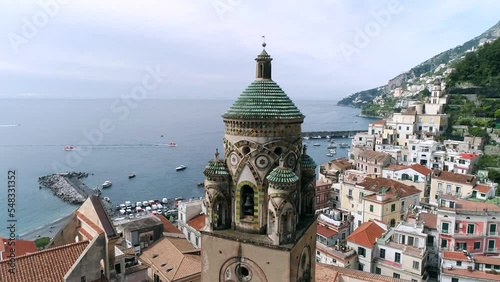 Aerial view of Amalfi Coast, Italy. Drone view of Cathedral of Saint Andrew, embankment, red roofs of buildings in old town, historical and tourist places, and cruise ship