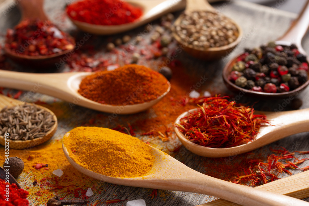 Paprika, pepper and turmeric spice in spoon at table background. Variety of spices and ingredients