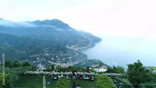 Aerial view of Belmond Hotel Caruso in Ravello, Italy.
 and the Amalfi Coast, Italy. A drone flies through the arch of the building towards the Tyrrhenian Sea and embankment photo