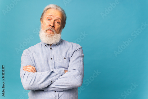 Portrait of surprised grey hair beard grandfather old man over blue color background with copy space