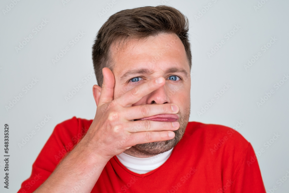 man closes a mouth hands being afraid to smile or speak. Teeth problem