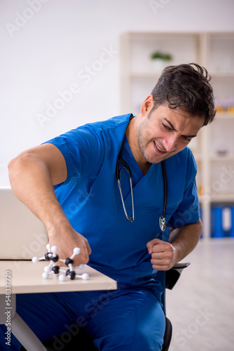 Young male student doctor holding molecular model