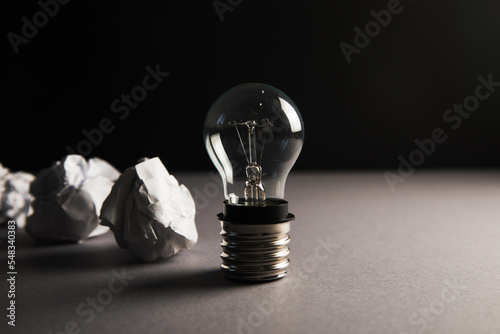 Crumpled papers and a light bulb. Concept discarded ideas