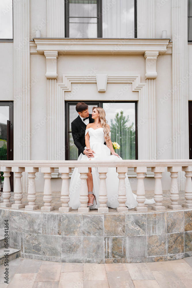 Beautiful bride and groom blonde on the balcony of a classic building. 