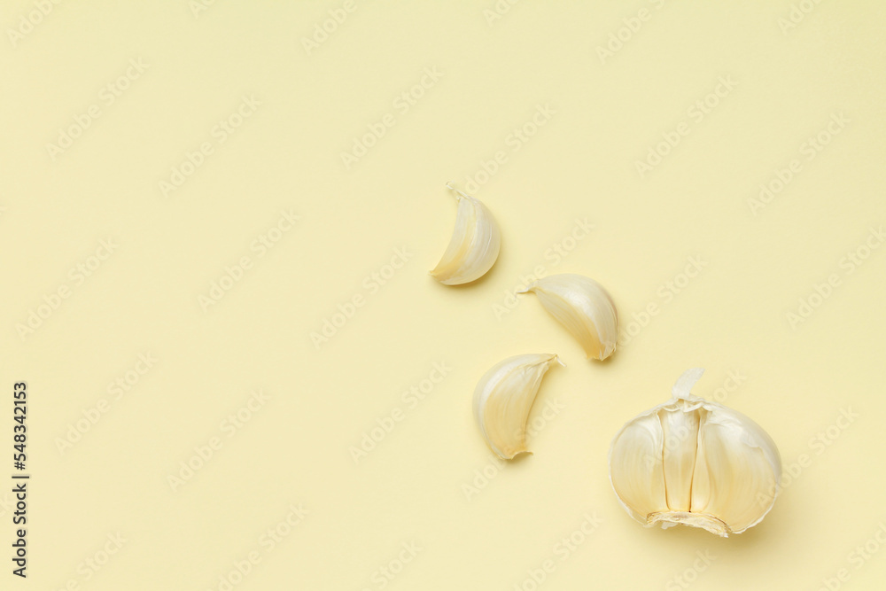 Fresh white garlic cloves on yellow color background. Vegan, organic, vitamins. Natural antibiotic, antioxidant, Allicin. Top view. Flat lay. Copy space for text