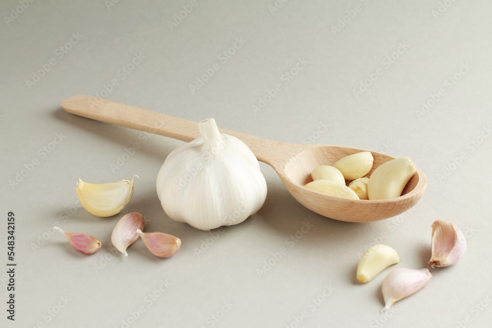 Fresh white unpeeled head bulb of garlic and garlic cloves on white