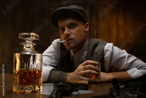 Foto Cards and revolver lying on table in front of dissatisfied gangster