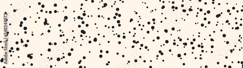 Spots pattern on nude background. Horizontal panoramic banner template. Irregular dots pattern. Creative small splash blots pattern. Abstract black stains on beige backdrop.
