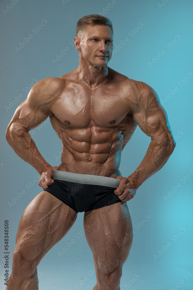 Well built athletic male model without clothes posing on white background