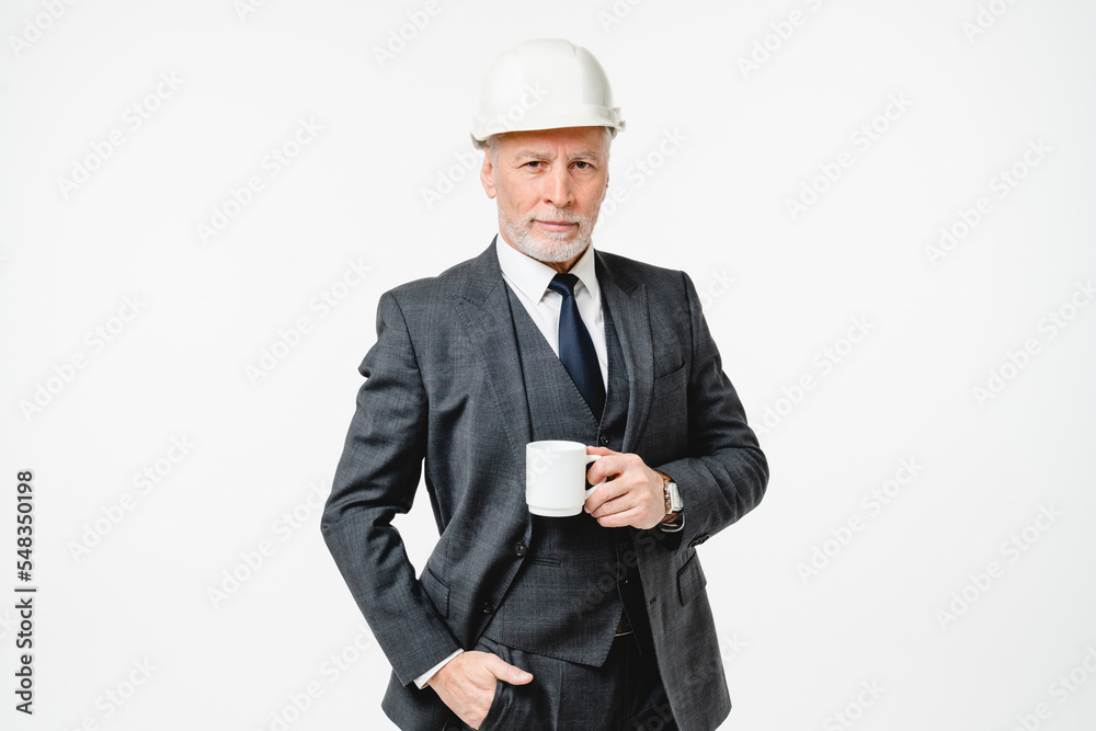 Middle-aged caucasian senior engineer architect construction worker in hardhat drinking coffee tea hot beverage isolated in white background Middle-aged caucasian senior engineer architect construction worker in hardhat drinking coffee tea hot beverage isolated in white background