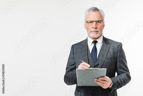 Confident caucasian mature middle-aged inspector businessman auditor advisor with clipboard writing checking info, doing paperwork in white background photo