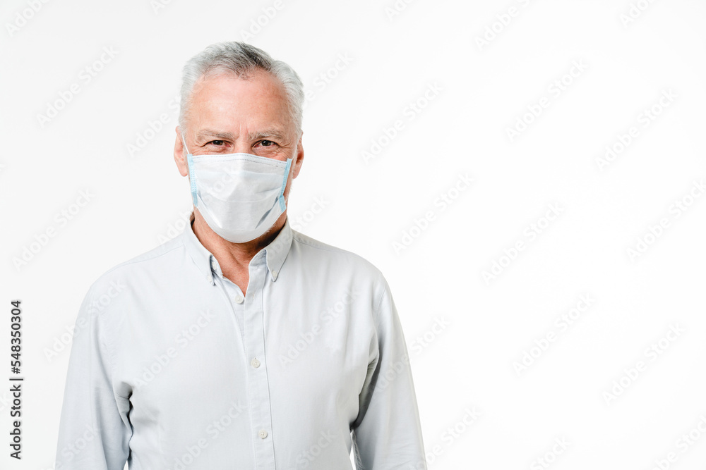 Mature middle-aged businessman freelancer grandfather wearing protective face mask against coronavirus isolated in white background. Pandemic concept. Social distance Mature middle-aged businessman freelancer grandfather wearing protective face mask against coronavirus isolated in white background. Pandemic concept. Social distance