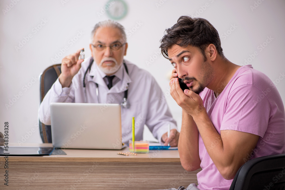 Young male patient visiting old male doctor Young male patient visiting old male doctor