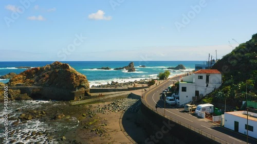 Rocky ocean coast with mountain touristic spot settlement small village in the north of Tenerife Island. Almaciga main street with beach Roque de las Bodegas. Canaries Spain. photo