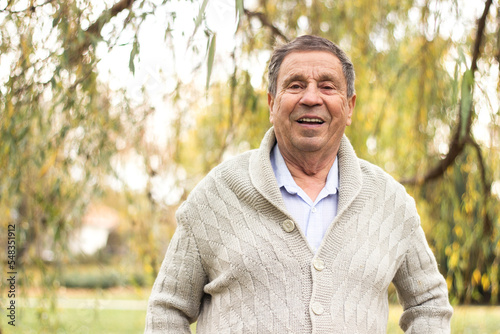 Portrait of a smiling senior man in an autumn park