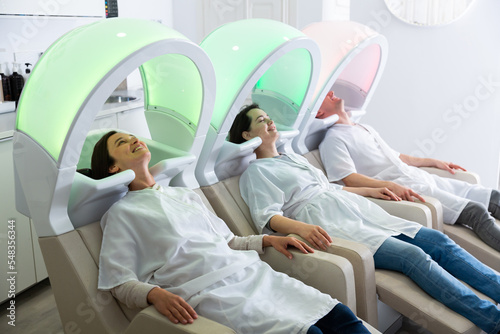 Male and female visitors of modern hair studio relaxing on massaging chairs before washing head