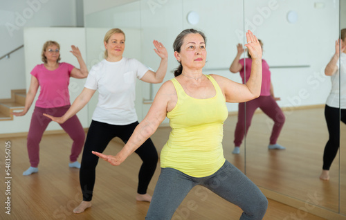 Elderly women maintaining mental and physical health attending yoga class at studio
